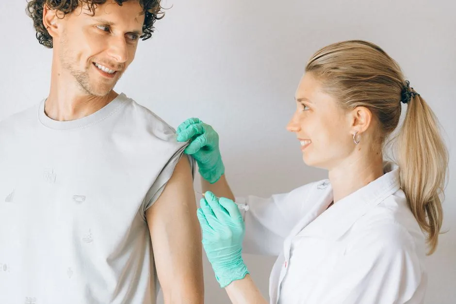 Pharmacist giving a smiling man a vaccination in his upper arm